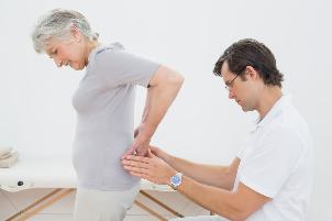 the doctor looks at the lower part of the back of the patient's